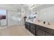 Main bathroom with double vanity, large shower, and dark wood cabinets at 4122 S 185Th Ln, Goodyear, AZ 85338