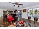 Living room with dark hardwood floors, red accent chair, and kitchen view at 4122 S 185Th Ln, Goodyear, AZ 85338