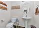 Stylish powder room with pedestal sink and decorative wall art at 4122 S 185Th Ln, Goodyear, AZ 85338