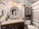 Bathroom with granite countertop, round mirror, and linen cabinet at 6433 W Cortez St, Glendale, AZ 85304