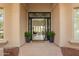 Charming front entrance features an open glass door, potted greenery, and views into the home at 9655 N 130Th St, Scottsdale, AZ 85259
