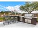 Modern outdoor kitchen with grill and bar seating at 9655 N 130Th St, Scottsdale, AZ 85259