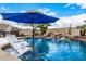 Relaxing pool scene with patio furniture and blue umbrella at 9655 N 130Th St, Scottsdale, AZ 85259