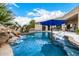 Inviting pool with waterfall feature, patio furniture, and blue umbrella at 9655 N 130Th St, Scottsdale, AZ 85259