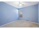 This bedroom features a neutral carpet, light blue walls, a window, and a ceiling fan at 10626 E Voax Dr, Sun Lakes, AZ 85248