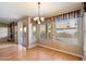 Cozy dining area with wood flooring, a chandelier, and a large window overlooking the backyard at 10626 E Voax Dr, Sun Lakes, AZ 85248