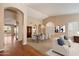 Bright dining room with a large table, chairs, chandelier, wood flooring, and arched entryway at 10626 E Voax Dr, Sun Lakes, AZ 85248