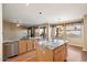 Bright kitchen featuring wood cabinets, a central island, and views of the backyard at 10626 E Voax Dr, Sun Lakes, AZ 85248