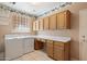 This laundry room includes a washer, dryer, cabinets, and a folding counter at 10626 E Voax Dr, Sun Lakes, AZ 85248