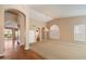 Bright living room showcasing arched doorways and a large window with plantation shutters at 10626 E Voax Dr, Sun Lakes, AZ 85248