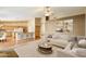 Inviting living room flowing into an open kitchen with stainless steel appliances and counter seating at 10626 E Voax Dr, Sun Lakes, AZ 85248