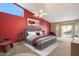 Spacious main bedroom with ensuite bathroom, featuring bright natural light, fan, and red accent wall at 10626 E Voax Dr, Sun Lakes, AZ 85248