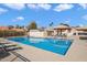 Community pool with chairs and cabanas at 10626 E Voax Dr, Sun Lakes, AZ 85248