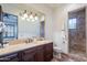 Bathroom with a large mirror, single vanity and shower at 10712 E Greythorn Dr, Scottsdale, AZ 85262