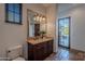 Bathroom with single vanity, toilet and door to exterior at 10712 E Greythorn Dr, Scottsdale, AZ 85262