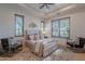 Bright bedroom with two armchairs and a ceiling fan at 10712 E Greythorn Dr, Scottsdale, AZ 85262