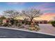 Stunning desert home with beautiful landscaping and three-car garage at sunset at 10712 E Greythorn Dr, Scottsdale, AZ 85262