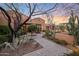 Landscaped entry with a paved walkway leading to a beautiful Spanish-style home at 10712 E Greythorn Dr, Scottsdale, AZ 85262