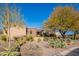 Landscaped front yard with mature trees and desert plants of a luxury home at 10712 E Greythorn Dr, Scottsdale, AZ 85262