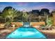 Luxury resort-style pool with fountain and lounge chairs at dusk at 10712 E Greythorn Dr, Scottsdale, AZ 85262