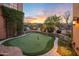 Landscaped backyard putting green with scenic sunset view at 10712 E Greythorn Dr, Scottsdale, AZ 85262