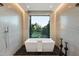 Modern bathroom with freestanding tub and large window overlooking backyard at 11952 E Casitas Del Rio Dr, Scottsdale, AZ 85255