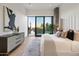 Modern bedroom with large window and city views, featuring a dresser and king bed at 11952 E Casitas Del Rio Dr, Scottsdale, AZ 85255