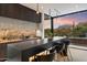 Contemporary kitchen with bar seating and sunset mountain views at 11952 E Casitas Del Rio Dr, Scottsdale, AZ 85255