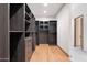 Modern walk-in closet with dark wood finishes at 11952 E Casitas Del Rio Dr, Scottsdale, AZ 85255