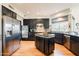 Spacious kitchen with dark cabinetry, granite island, and stainless steel appliances at 12026 N 138Th St, Scottsdale, AZ 85259