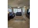 Spacious living room featuring tiled floors, comfy leather furniture, and a large window at 12411 N Cantata Ct, Sun City, AZ 85351