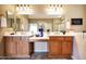 Bathroom featuring double sinks, wooden cabinets, and a decorative vanity at 13129 W Junipero Dr, Sun City West, AZ 85375