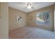 Serene bedroom with neutral decor, large window, and ceiling fan at 13129 W Junipero Dr, Sun City West, AZ 85375