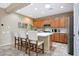 Well-lit kitchen featuring an island with bar stools, stainless steel appliances, and modern finishes at 13129 W Junipero Dr, Sun City West, AZ 85375