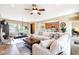 Spacious living room with ceiling fan, and seamless access to kitchen island at 13129 W Junipero Dr, Sun City West, AZ 85375