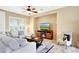 Cozy living area with comfortable seating, a fireplace, and a ceiling fan at 13129 W Junipero Dr, Sun City West, AZ 85375