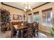 Elegant dining room with a wood table, stylish chandelier, and natural light from large windows at 17844 E Pacana Ct, Gold Canyon, AZ 85118