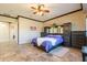 Spacious bedroom with tile floors, ceiling fan, adjacent dressing area and beautiful natural light at 17844 E Pacana Ct, Gold Canyon, AZ 85118