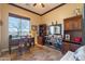 Comfortable home office has tile floors, a ceiling fan and lots of natural light from the window at 17844 E Pacana Ct, Gold Canyon, AZ 85118