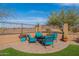 Relaxing patio area with turquoise seating, surrounded by lush greenery and a private backyard fence at 17844 E Pacana Ct, Gold Canyon, AZ 85118