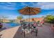 Outdoor dining on a brick patio, complemented by a sparkling pool and scenic backyard at 17844 E Pacana Ct, Gold Canyon, AZ 85118