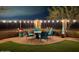 Enchanting outdoor patio illuminated with string lights, complete with comfortable seating and lush landscaping at 17844 E Pacana Ct, Gold Canyon, AZ 85118