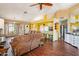 Spacious living room featuring hardwood floors, a fan, and easy transition to the kitchen and entry way at 1801 E Aire Libre Ave, Phoenix, AZ 85022