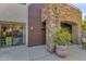 Stone exterior with arched entryway and landscaping at 19550 N Grayhawk Dr # 1107, Scottsdale, AZ 85255