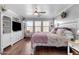 Main bedroom with king bed, built-in shelving, and hardwood floors at 19646 E Reins Rd, Queen Creek, AZ 85142