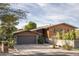 House exterior showcasing a modern design with wood siding and a two-car garage at 2235 E Vista Ave, Phoenix, AZ 85020