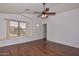 Bright bedroom with hardwood floors, large window, and ceiling fan at 22830 N 32Nd Ln, Phoenix, AZ 85027