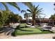 Backyard with a putting green, patio, palm trees and a lounge area creating a relaxing outdoor space at 31689 N Blackfoot Dr, San Tan Valley, AZ 85143