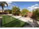 Backyard putting green with artificial grass and trees, perfect for outdoor recreation and relaxation at 31689 N Blackfoot Dr, San Tan Valley, AZ 85143