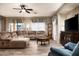 Living room with sectional sofa, wood floors, and a large flat-screen TV at 33610 N 26Th Ave, Phoenix, AZ 85085